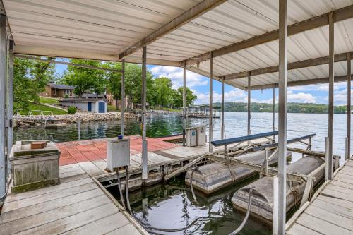 a dock with a boat on the water at Unforgettable Lake Memories in Lake Ozark
