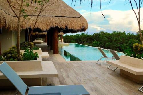 un complejo con piscina, sillas y piscina en 1 Rec. | Vista a la Jungla + Piscina Infinita + Amenidades LX, en Tulum
