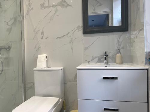 a bathroom with a toilet and a sink and a mirror at Grand Bleu - London - Next to Piccadilly Line Tube Station & Brand New Facilities in London