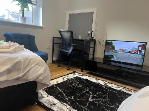 a bedroom with a bed and a flat screen tv at Grand Bleu - London - Next to Piccadilly Line Tube Station & Brand New Facilities in London