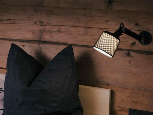 a lamp hanging on a wall next to a book at Chalet in Montafon with Private Sauna & Views in Vandans