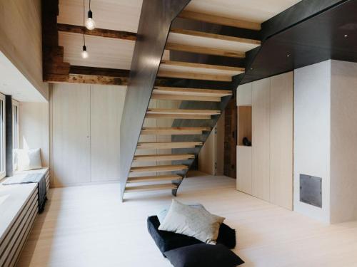 a staircase in a room with a couch and a bed at Chalet in Montafon with Private Sauna & Views in Vandans