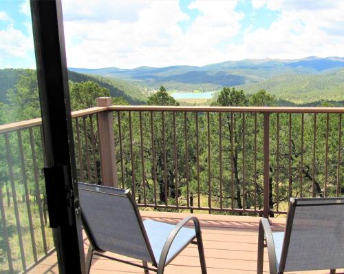 a balcony with two chairs and a view of the mountains at High Sierra Condominiums in Ruidoso