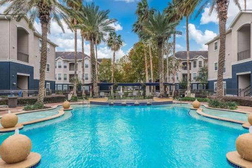 una piscina en un complejo con palmeras en Beautiful spacious apartment !, en Webster