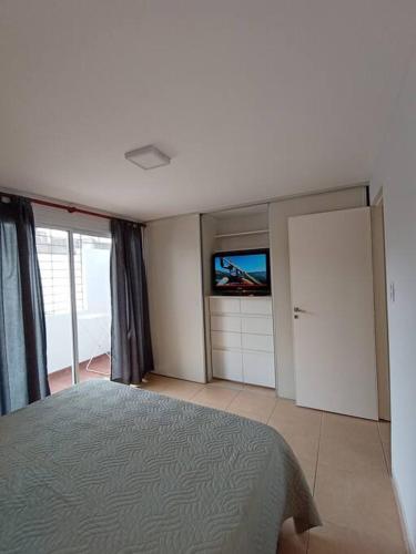a bedroom with a bed and a flat screen tv at Las Piedras Apart in San Miguel de Tucumán