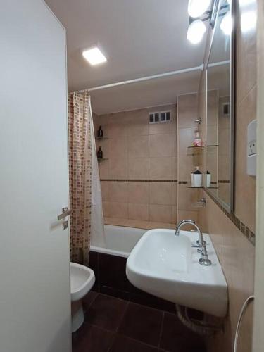 a bathroom with a sink and a tub and a toilet at Las Piedras Apart in San Miguel de Tucumán