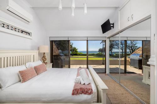 sypialnia z dużym łóżkiem i przesuwnymi szklanymi drzwiami w obiekcie A Fisherman's Rest w mieście Nelson Bay