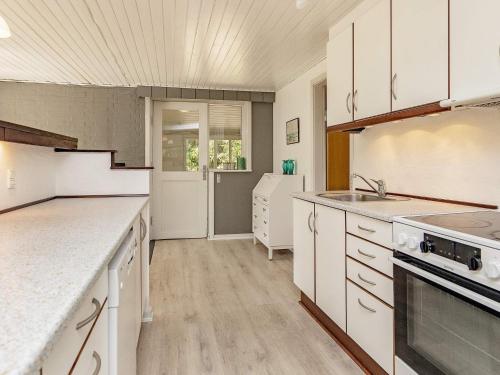 a kitchen with white cabinets and a sink and a stove at 6 person holiday home in Højslev-By Traum in Højslev