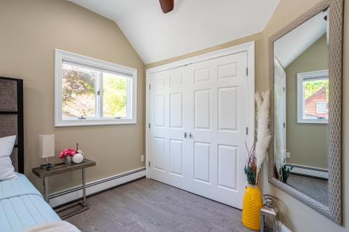 a bedroom with a white door and a mirror at Elegance at Huntington Spacious Family Apt Yard in Huntington Station