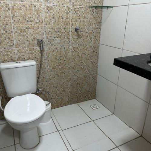a bathroom with a toilet and a shower at Pousada Maré Forte in Cascavel