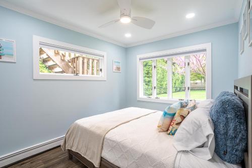 a bedroom with a bed and two windows at Elegance at Huntington Spacious Family Apt Yard in Huntington Station