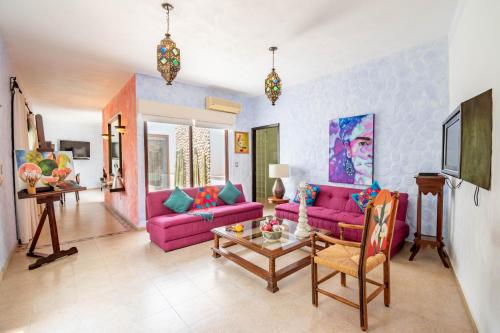 a living room with pink couches and a table at Quinta Las Acacias Hotel Boutique in Guanajuato