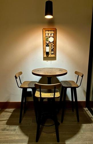 a table and two chairs sitting next to a wall at Lavandas de Cunha Pousada Boutique in Cunha
