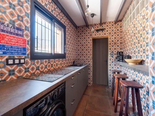 a kitchen with orange and blue tiles on the wall at Villa Jen'uka with private pool in Callian