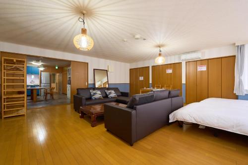 een slaapkamer met een bed en een bed en een bank bij Haneda Lex Apartment in Tokyo