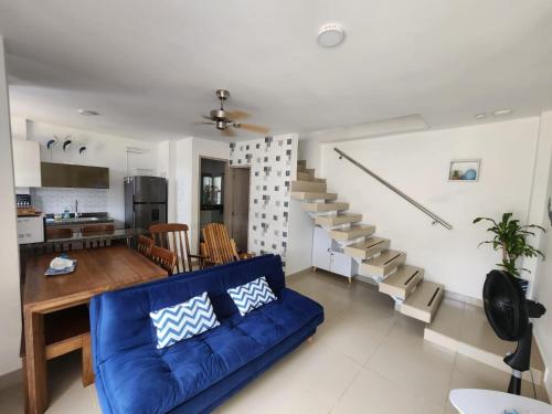 salon z niebieską kanapą i schodami w obiekcie Loft 39 w mieście Coveñas