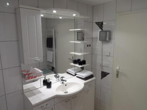 a white bathroom with a sink and a mirror at Gästehaus Ehrlich in Prien am Chiemsee