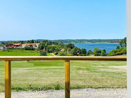a fence with a view of a field and water at 8 person holiday home in UDDEVALLA-By Traum in Sundsandvik