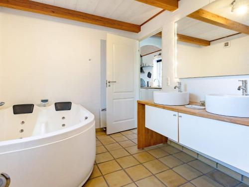 a bathroom with a large tub and two sinks at Holiday home Nykøbing M VII 