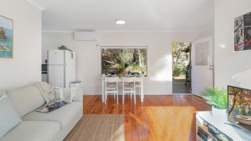 a living room with a white couch and a table at Kangaroo Cottage in Currarong