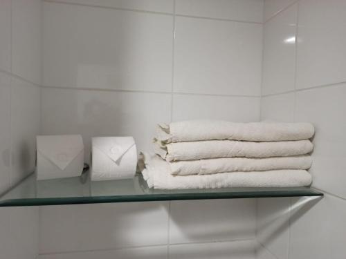 un estante de cristal con toallas en el baño en Manaira Flat, en João Pessoa
