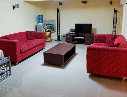 a living room with two red couches and a tv at Aspley property in Brisbane