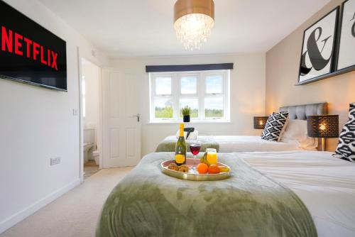 a bedroom with two beds and a table with fruit on it at Detached House with Free Parking, Super-Fast Wifi and Smart TV with Netflix by Yoko Property in Northampton
