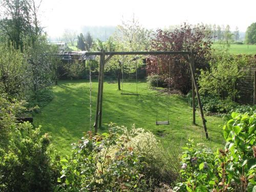 a swing set in the middle of a garden at Huis van Rooi in Sint-Agatha-Rode