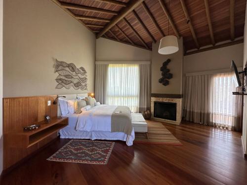 a large bedroom with a bed and a fireplace at Lavandas de Cunha Pousada Boutique in Cunha