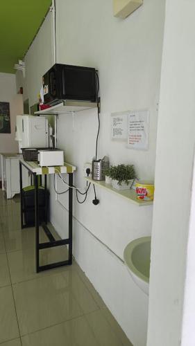 a kitchen with a sink and a microwave on a wall at Olive Hotel in Johor Bahru