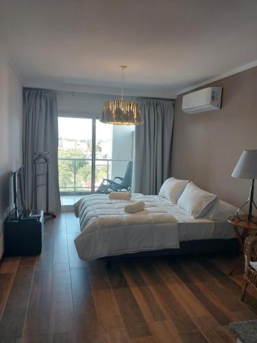 um quarto com uma cama grande e um lustre em MONOAMBIENTE - Parana TU CASA em Paraná