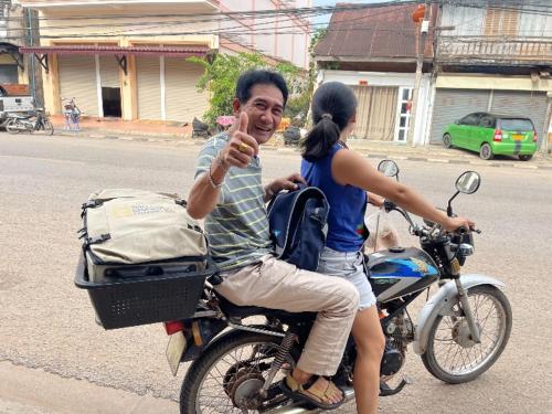 a man and a woman riding on a motorcycle at Bami hostel in Thakhek