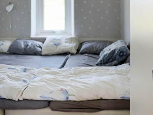 1 cama con almohadas en el dormitorio en Holiday home Åskloster II, en Åskloster