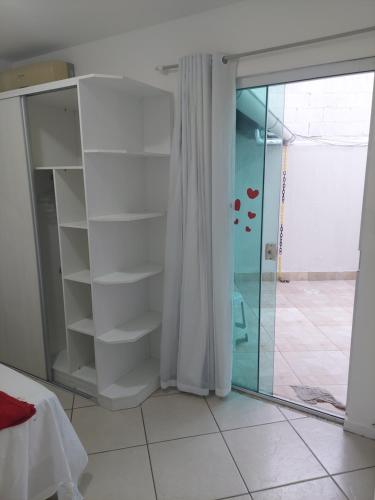 Habitación con puerta de cristal y ducha. en Apartamento na Praia dos Anjos, en Arraial do Cabo
