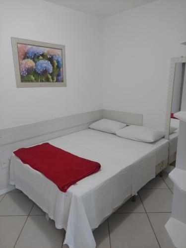 1 cama en una habitación con una foto en la pared en Apartamento na Praia dos Anjos, en Arraial do Cabo