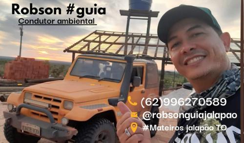 a man holding up a picture of a truck at Pousada Status Jalapão in Mateiros