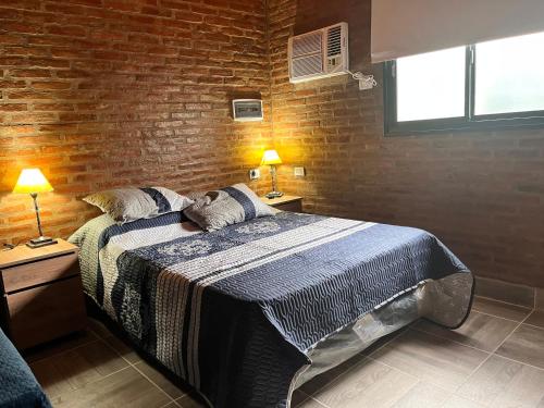 a bedroom with a bed and a brick wall at Cabañas las brisas in La Banda