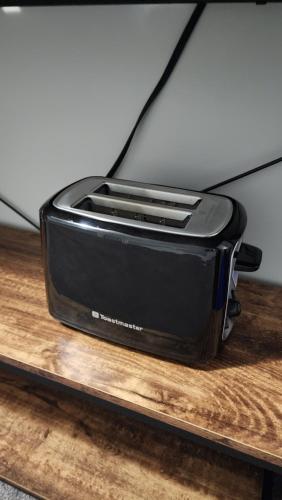 a black toaster sitting on top of a wooden table at The Jade Place in Airdrie