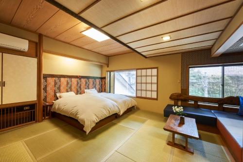 Shima-Onsen Toshimaya في Nakanojo: غرفة نوم بسرير كبير وطاولة فيها