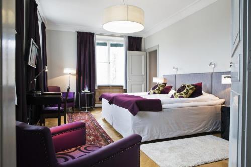 a hotel room with a large bed and a desk at Bofors Hotel in Karlskoga
