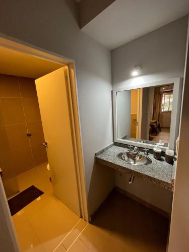 a bathroom with a sink and a mirror at Departamento Quality Belgrano in Santiago del Estero