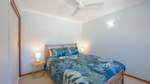 a bedroom with a bed and two lamps in it at Waratah in Iluka