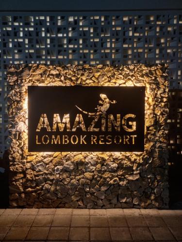 a sign for an mgm lobby resort at night at Amazing Lombok Resort in Selong Belanak