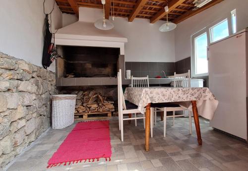 een eetkamer met een tafel en een stenen open haard bij House Maja in Jadrija