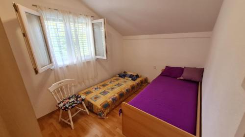 een kleine slaapkamer met een bed en een raam bij House Maja in Jadrija