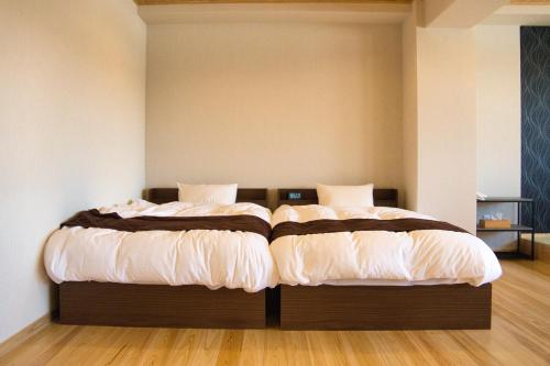 two beds sitting next to each other in a room at Tabist Hotel Chouseikaku in Yatsushiro