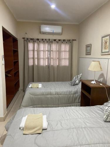 1 dormitorio con 2 camas y mesa con lámpara en Monoambiente Centrico en Santiago del Estero