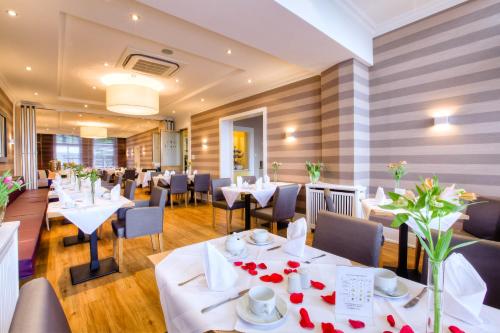 a dining room with white tables and chairs at Relexa Hotel Bellevue an der Alster in Hamburg