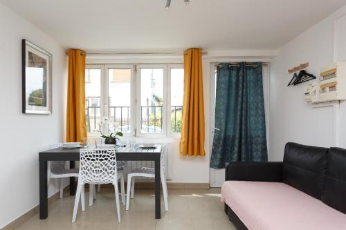 un salon avec une table et un canapé dans l'établissement Maison de ville le blanc mesnil, au Blanc-Mesnil