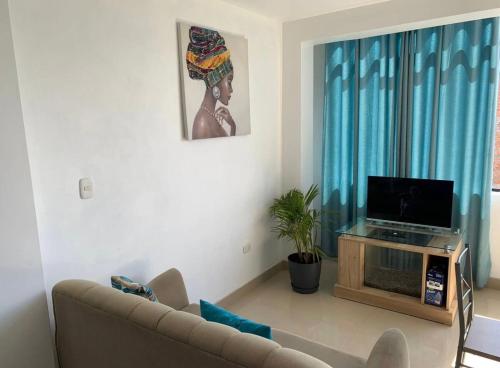 ein Wohnzimmer mit einem Sofa und einem Flachbild-TV in der Unterkunft Departamento en el centro histórico in Ayacucho